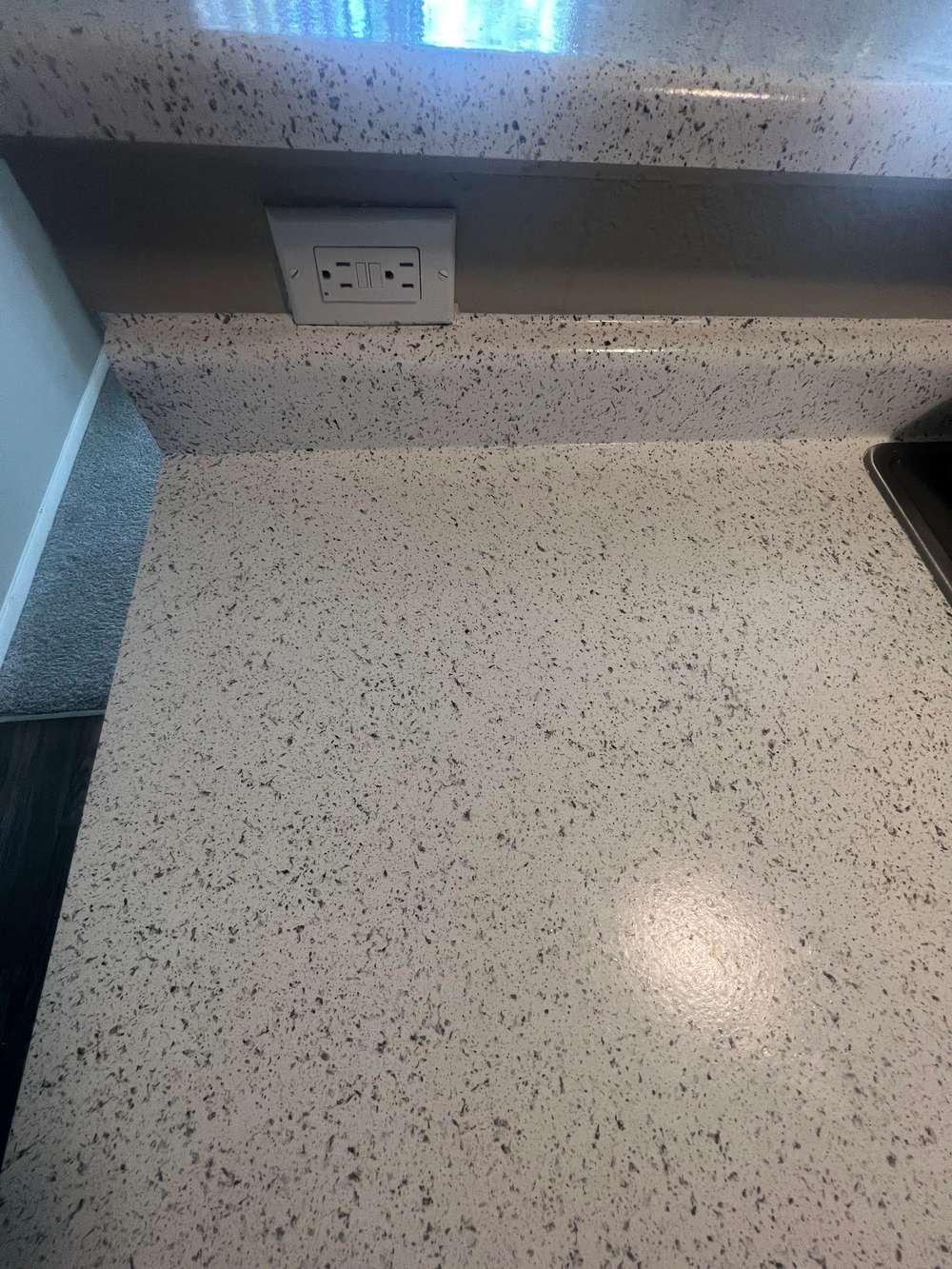 Speckled granite-look countertop and backsplash after resurfacing. Photo from the ADG Premium Services LLC site.